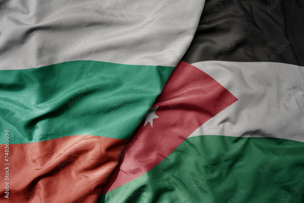 big waving national colorful flag of jordan and national flag of bulgaria .