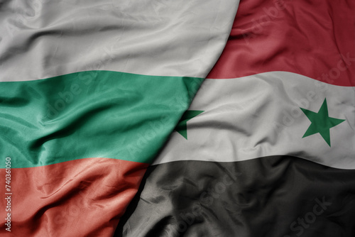big waving national colorful flag of syria and national flag of bulgaria .