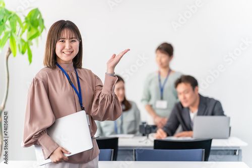 オフィス・会議室で案内するビジネスウーマン・女性（こちら・おすすめ・ガイド・誘導）
 photo