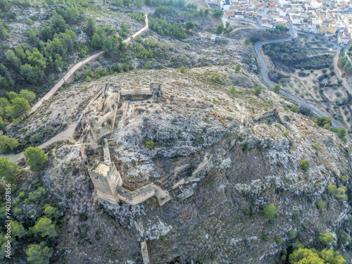 Aerial view of medieval Pliego castle partially restored curtain walls, square tower on a hilltop in Southern Spain photo