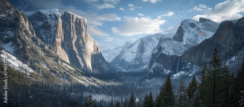 Majestic snow-capped mountain range with scattered trees in serene wilderness landscape
