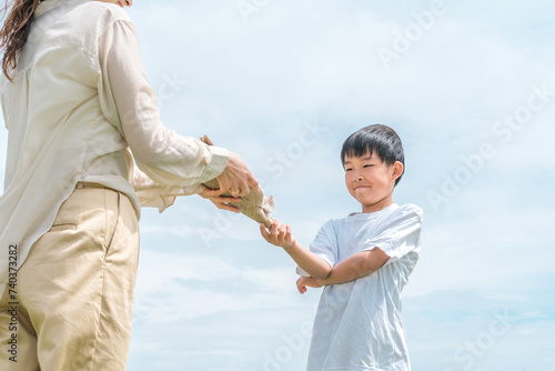ママにブーケ・花束・スワッグを渡す反抗期の子供・照れる男の子（感謝）
 photo