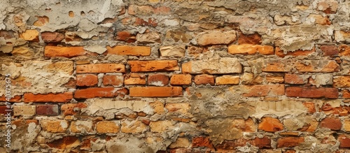A detailed shot showcasing an aged brick wall with weathered plaster peeling off, highlighting the natural beauty of brickwork and building materials