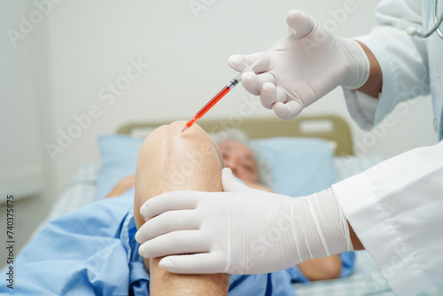 Asian doctor inject Hyaluronic acid platelet rich plasma into the knee of senior woman to walk without pain.