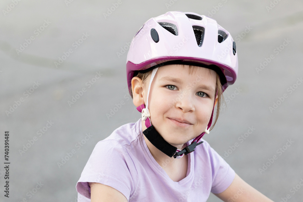 Smiling happy young child, a girl wearing a pink safety helmet with straps fastened, kid cyclist biker portrait, face closeup, outdoor activities, one person, real people lifestyle shot, childhood Smiling happy young child, a girl wearing a pink safety helmet with straps fastened, kid cyclist biker portrait, face closeup, outdoor activities, one person, real people lifestyle shot, childhood