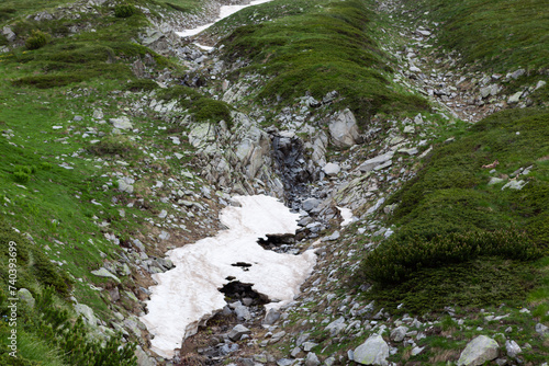 Green mountain slope on cloudy day. Landscape on hiking trail to Vihren peak. Pirin National Park in Bulgaria. photo