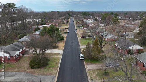 Asphalt road in suburb residential area of american city at cloudy day, Virginia. Aerial tilt up shot.