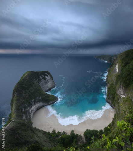 High angle view of ocean, Kelingking beach, bay and cliffs in tropical Nusa Penida island with heavy clouds and atmospheric mood