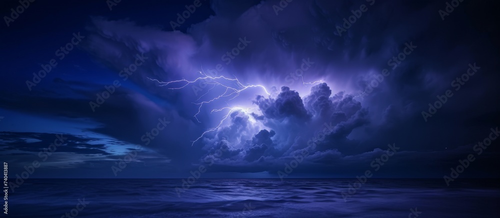 Dramatic lightning storm over the vast ocean during the night with dark cloudy sky