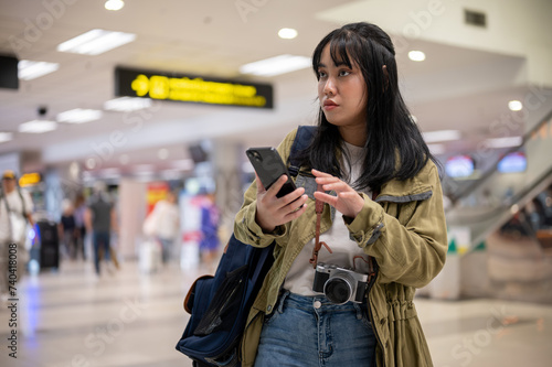 A female solo traveler or backpacker is walking in the airport, looking for her check-in counter.