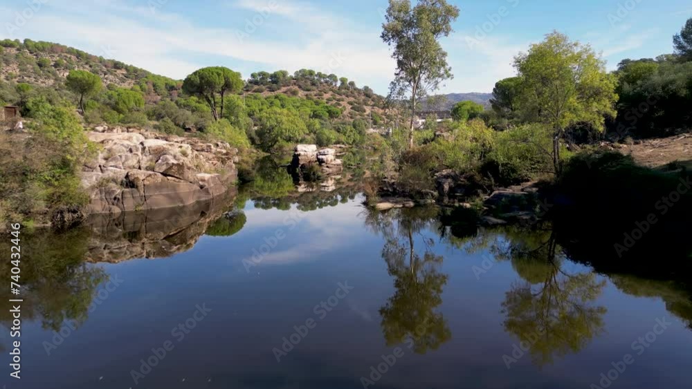 Aerial flight over tranquil river with beautiful scenic landscape reflections Sierra de Andujar Aerial flight over tranquil river with beautiful scenic landscape reflections Sierra de Andujar