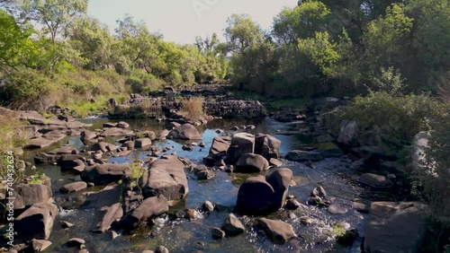 Drone flys low over rocky boulder strewn river in Sierra de Andujar nature reserve Spain photo