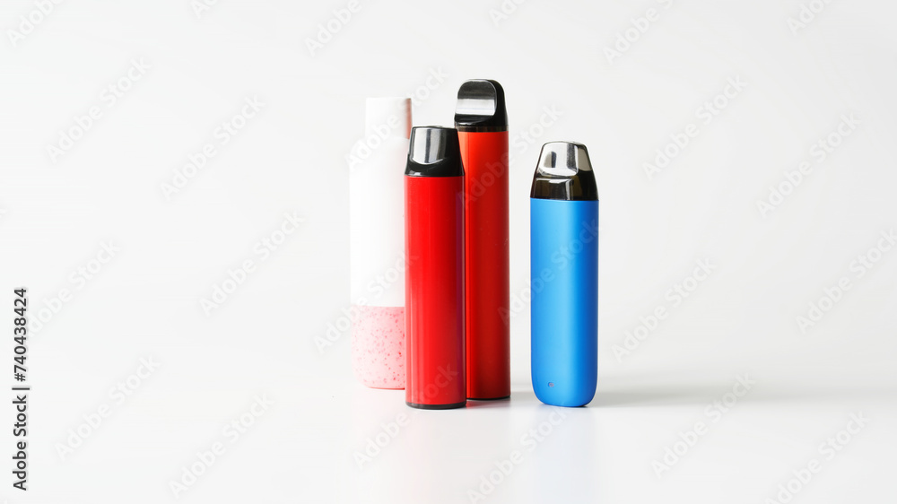Four multicoloured electronic cigarettes on white background. Copy space. Photo Four multicoloured electronic cigarettes on white background. Copy space. Photo
