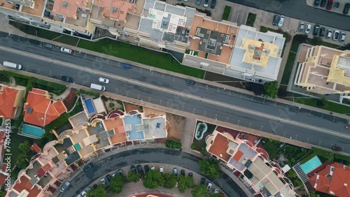 Drone urban road running on beautiful cozy town. Cars riding on asphalt roadway photo