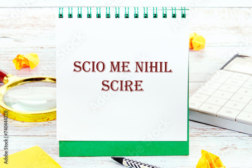 Scio me nihil scire It is translated from Latin as I know I don't know anything. It is written on a standing notebook photo
