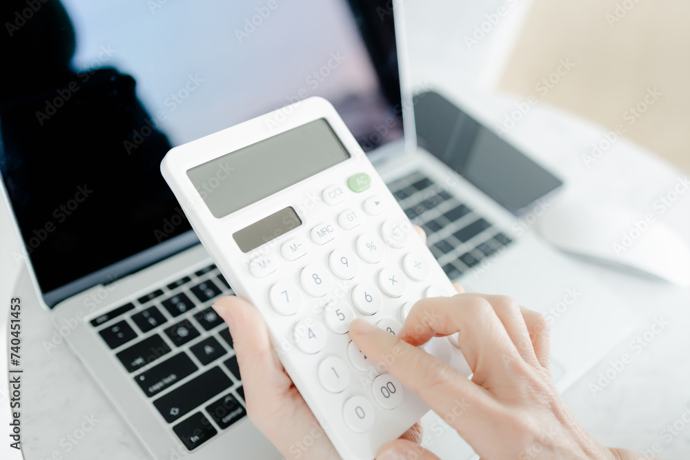 Business woman using a calculator to calculate the numbers on his desk in a office. Business woman using a calculator to calculate the numbers on his desk in a office.