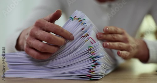 Businesswoman hands work in stacks of paper files to search for information in office on desktop