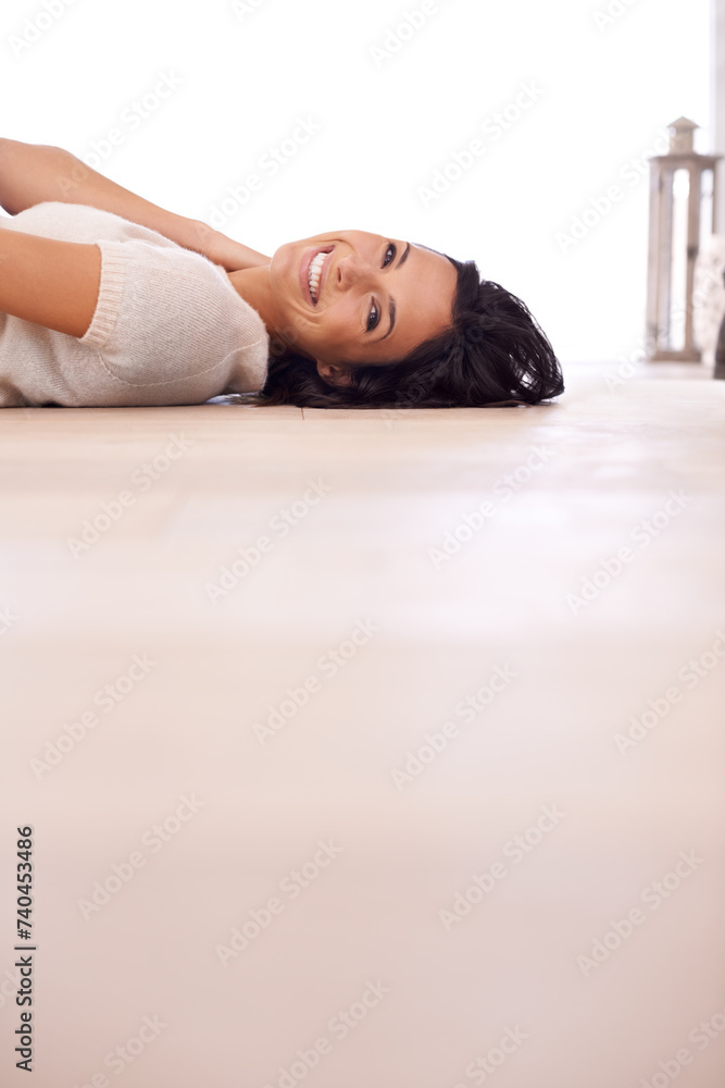 Fototapeta premium Woman, portrait and smile on floor for relax with mock up space, weekend break and confidence in apartment. Person, lying down and face with happiness in home on wooden flooring for fun and ground