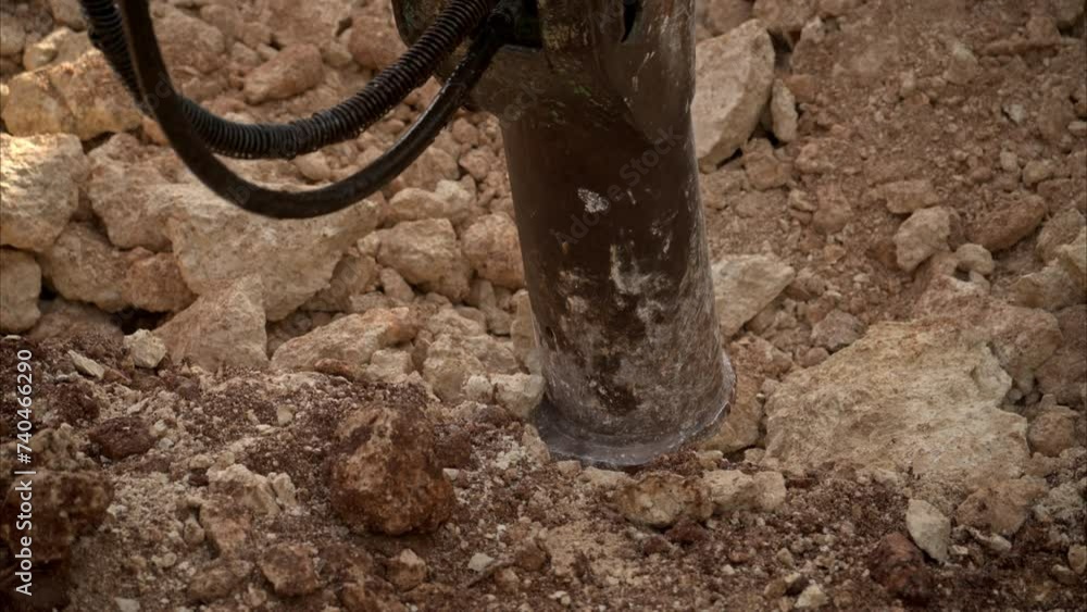 Slow motion close up of an hydraulic hammer shoveling and pushing rocks in a construction site Slow motion close up of an hydraulic hammer shoveling and pushing rocks in a construction site