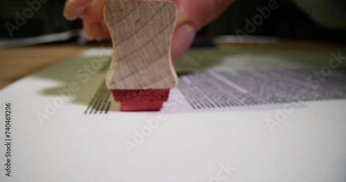 Manager hand with red rejected stamp when refusing visa to one of applicants