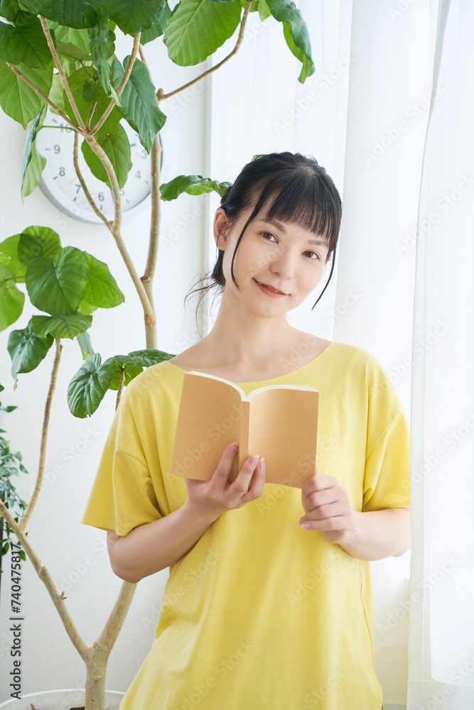 窓辺で本を読む女性