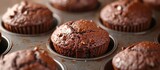 A batch of delectable chocolate muffins is arranged in a muffin tin, ready to be enjoyed as a delightful finger food treat