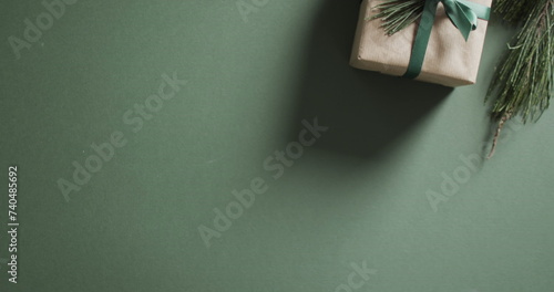 A gift box rests on a green surface, with copy space