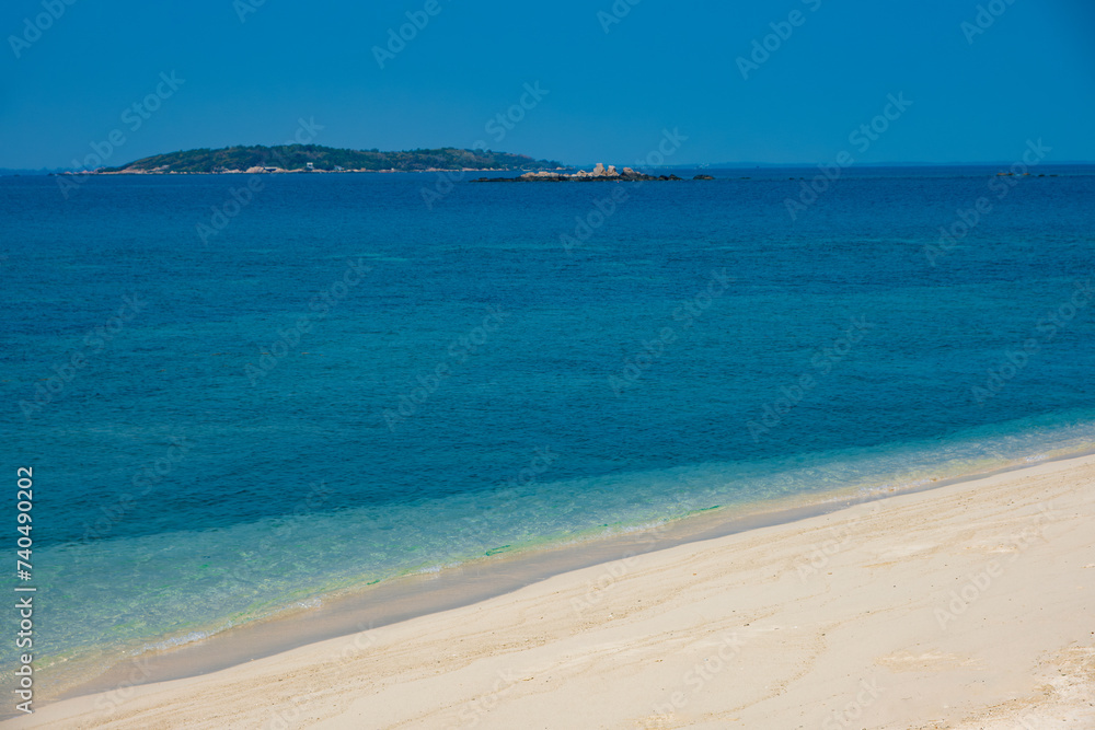 Aerial view of blue sea waves and beach for summer vacation concept. Nature of the beach and sea Summertime with sunshine, sandy beaches, and sparkling waters.	