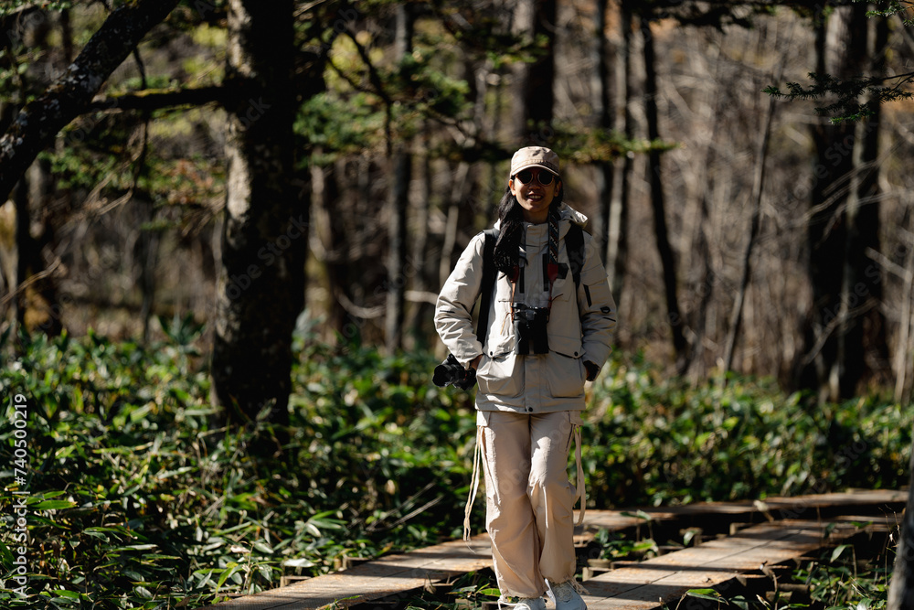 woman family walking in the forest to watching a bird in nature, using binocular for birding by looking on a tree, adventure travel activity in outdoor trekking lifestyle, searching wildlife in jungle woman family walking in the forest to watching a bird in nature, using binocular for birding by looking on a tree, adventure travel activity in outdoor trekking lifestyle, searching wildlife in jungle