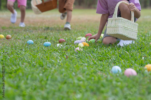 Group of children happily runs around pick up Easter eggs in the park, Easter egg hunt concept, selective focus
