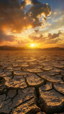 Sunset over arid landscape with dramatic sky and cracked ground. Ideal for environmental campaigns or climate change awareness.