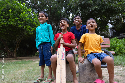 Group of boys sitting in the park with cricket bat photo