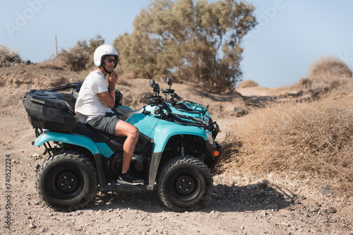 Young man securing helmet on a four wheeler atv on off road track