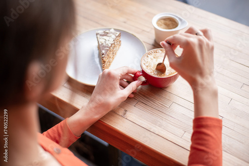 Cropped Shot of an Unrecognizable Woman Enjoying Coffee With Cake photo