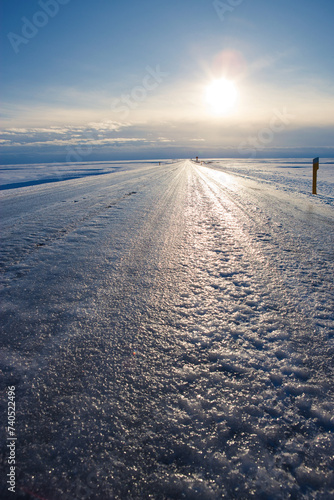 Dangerously Icy road and winter sun