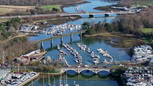 Aerial shot flying over Hamble River boatyard with bridges, boats and cars UK 4K photo