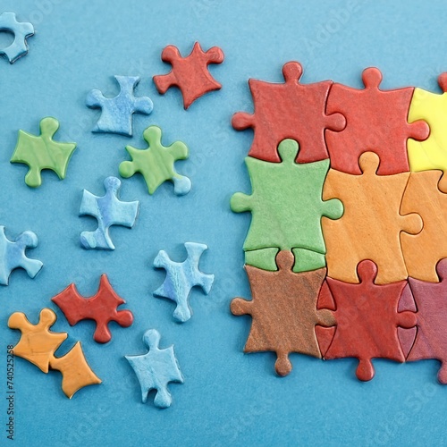 Mixed Peaces of a Colorful Jigsaw Puzzle Lie on the Blue Background