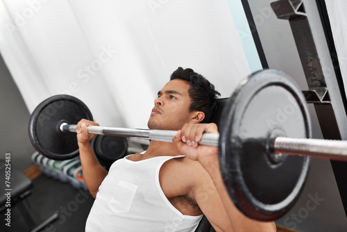 Bench, press and man at gym for workout, exercise and body building in Mexico. Healthy, person and weightlifting challenge for strong muscle, fitness or progress in training arms with barbell at club