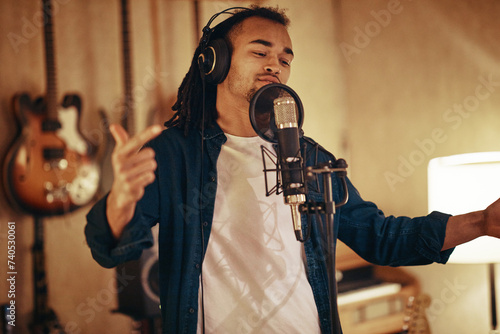 Young African American musician singing in a recording studio photo