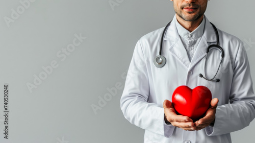 free space for title banner with Cardiologist doctor holding a red heart in his hands , cardiac disease or heart failure concept image on the right corner photo