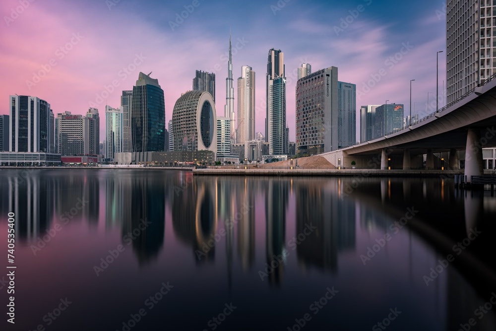 Dazzling Dubai skyline: Iconic skyscrapers, illuminated cityscape, and futuristic architecture against a sunset sky