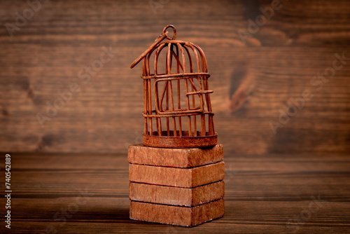Rusty bird cage on wood texture background. Captivity, prison and the concept of repression photo