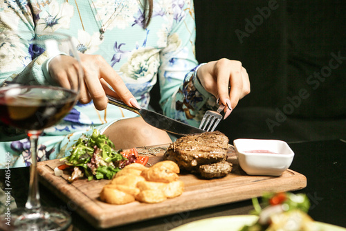 Woman Cutting Hamburger on Cutting Board