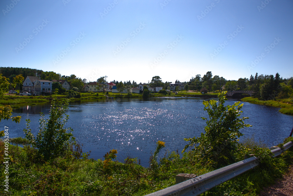 Scenic view of a blue river with lush vegetation and houses in Port Elgin, New Brunswick