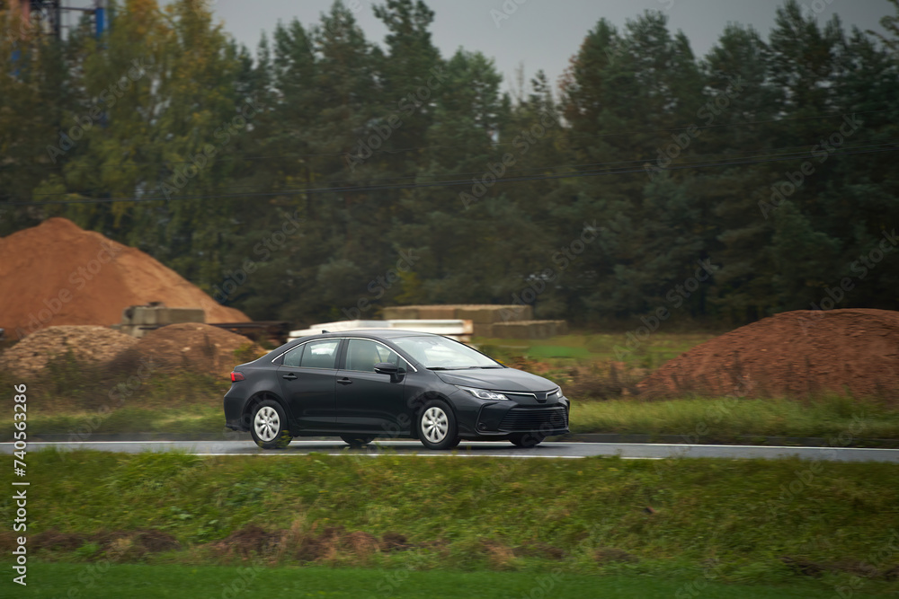 Driving a New and Fast Car on a Sunny Highway with a Beautiful Landscape