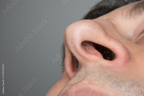 Up the nose, low angle shot of male nostril holes and nose hairs