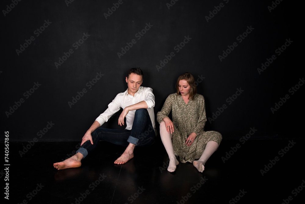 Fototapeta premium portrait of sitting couple on black background
