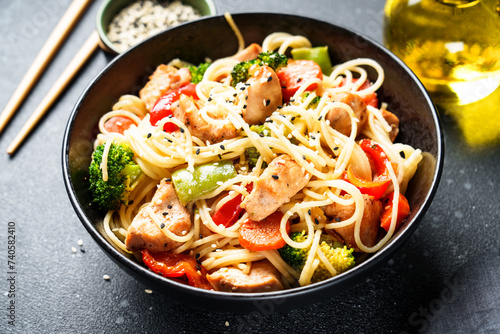 Asian noodles with chicken and vegetables at black background. Close up.