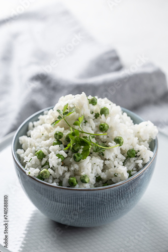 Jasmine rice with peas and parsley in a bowl on the table