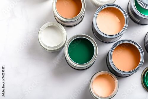 Tiny sample paint cans during house renovation, process of choosing paint for the walls, Peach Fuzz color of the year 2024, color charts on background